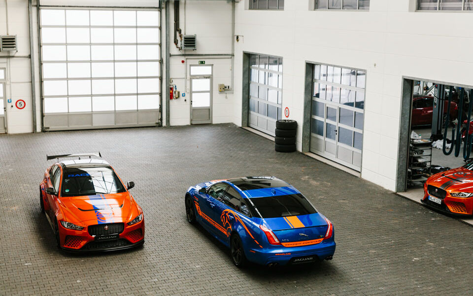 Blauer und orangefarbener Jaguar in einer Autogarage von oben fotografiert