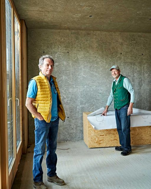 Anderl Friedinger (links) und Karl-Michael Friedinger (rechts) stehen in Raum mit unverputzten Wänden