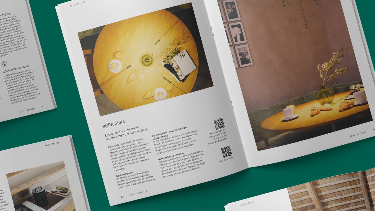 Open double page of BORA magazine with photos of laid tables in a modern living room Open double page of BORA magazine with photos of laid tables in a modern living room