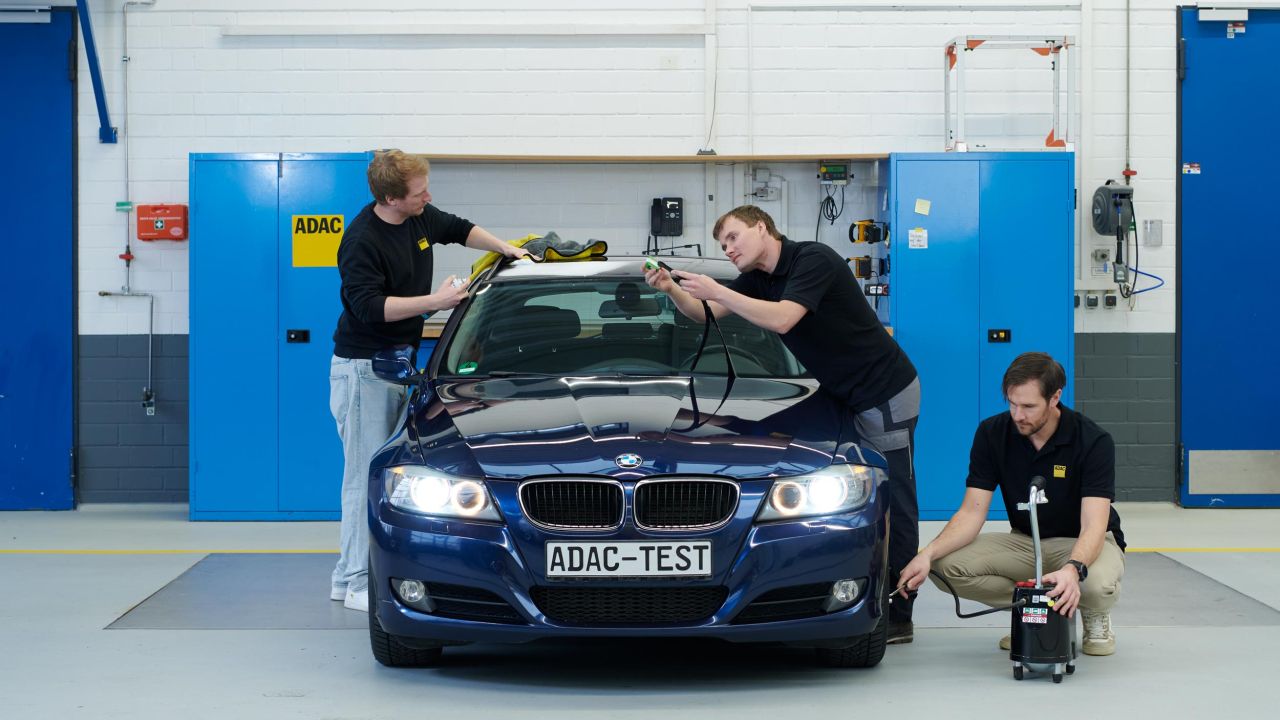 Nahaufnahme eines ADAC-Mitarbeiters, der einen Scheibenwischer mit einem kleinen Messgerät überprüft Nahaufnahme eines ADAC-Mitarbeiters, der einen Scheibenwischer mit einem kleinen Messgerät überprüft