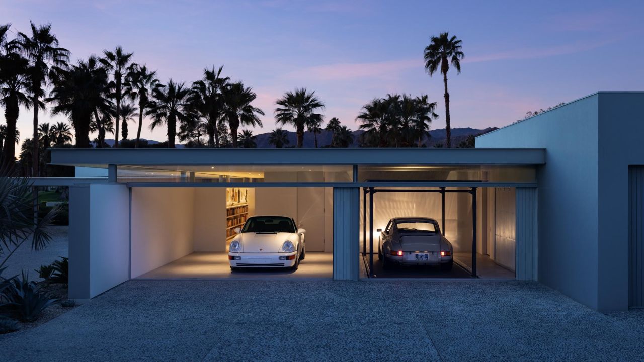 Modern garage building at dusk with two classic Porsches and palm trees in the foreground Modern garage building at dusk with two classic Porsches and palm trees in the foreground