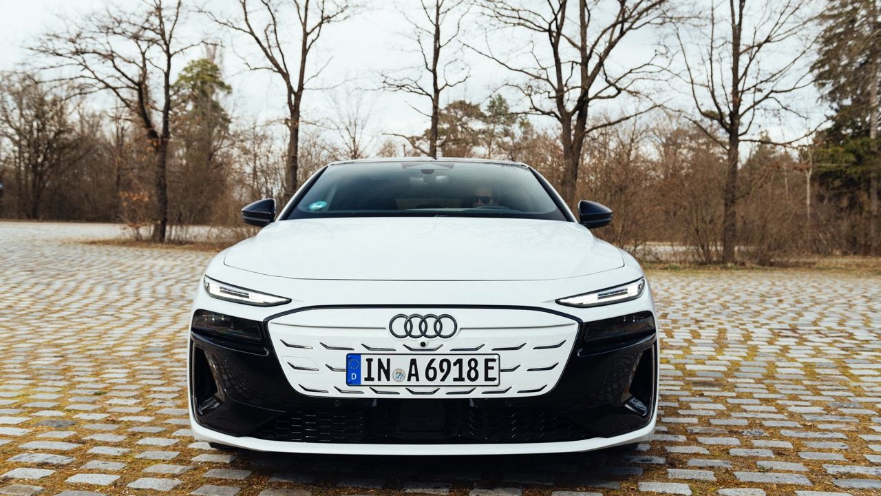 Front view of a white Audi A6 Sportback e-tron parked on cobblestones